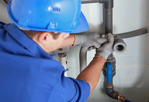 plumber working on under counter plumbing issues